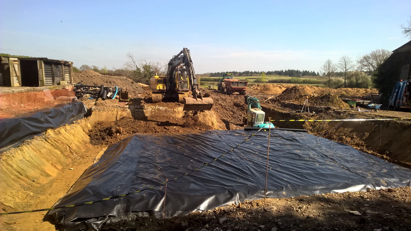 Excavation site with cell barrier being laid in the ground