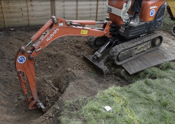 Small digger excavating soils from a garden