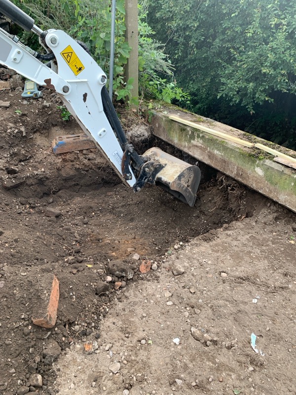 Excavator removing soil from knotweed site