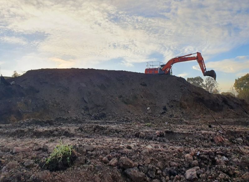 A large mound of soils that have been excavated and piled up into one area.