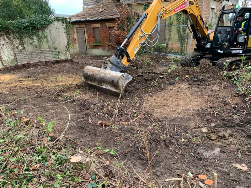 An excavator scraping the top surface of land